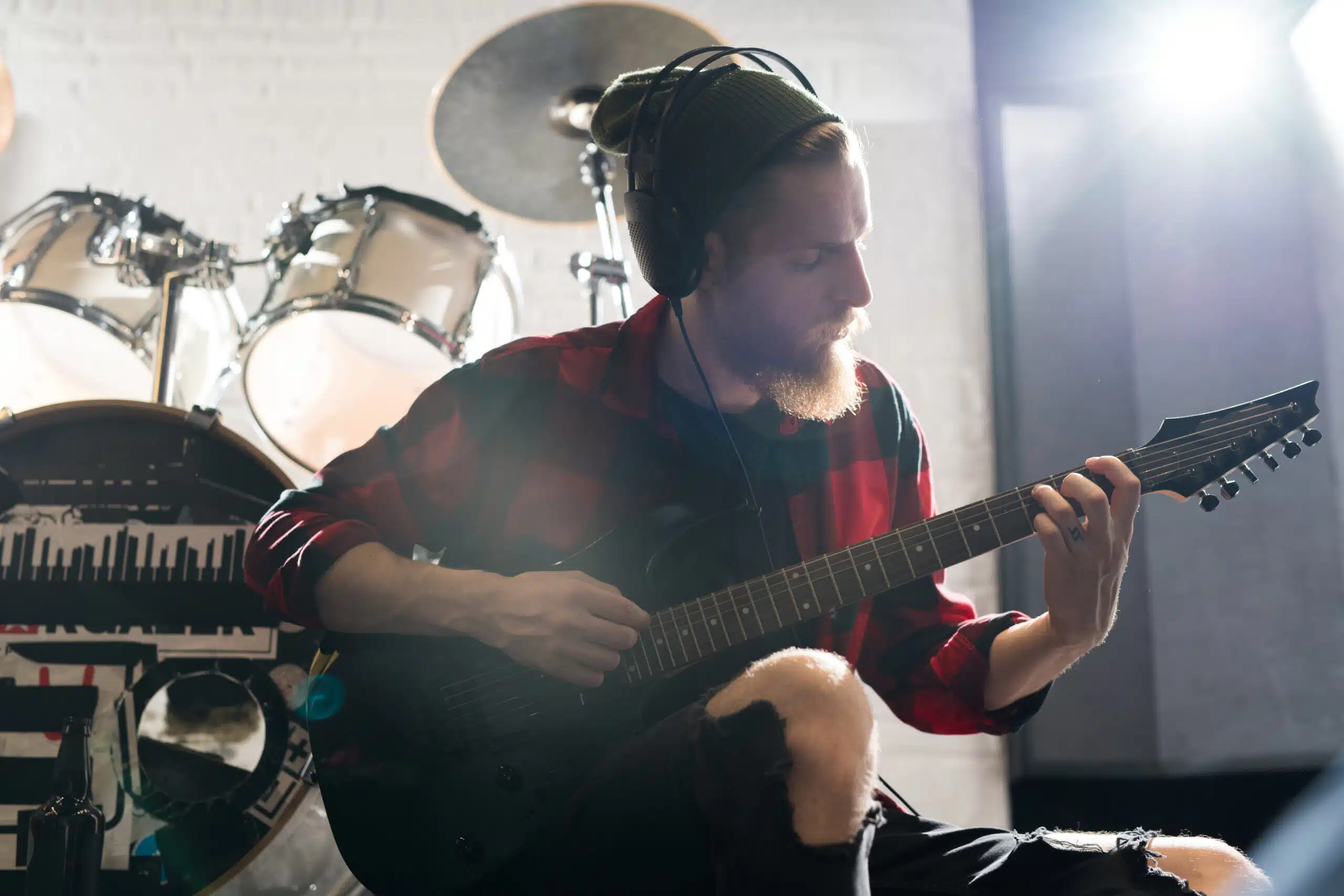 Waist up portrait of handsome bearded man playing guitar in rehearsal studio, copy space